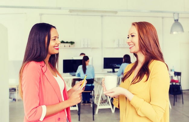 Photo business, startup and people concept - happy creative women talking at office