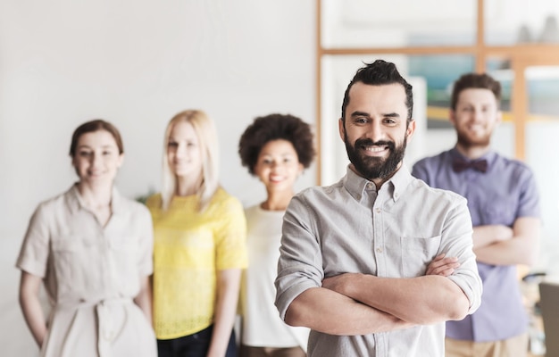 Foto business, startup, persone e concetto di lavoro in squadra - giovane felice con la barba sopra il team creativo in ufficio