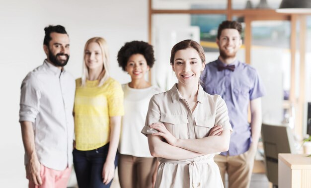 Foto concetto di business, startup, persone e lavoro di squadra - giovane donna felice nel team creativo in ufficio