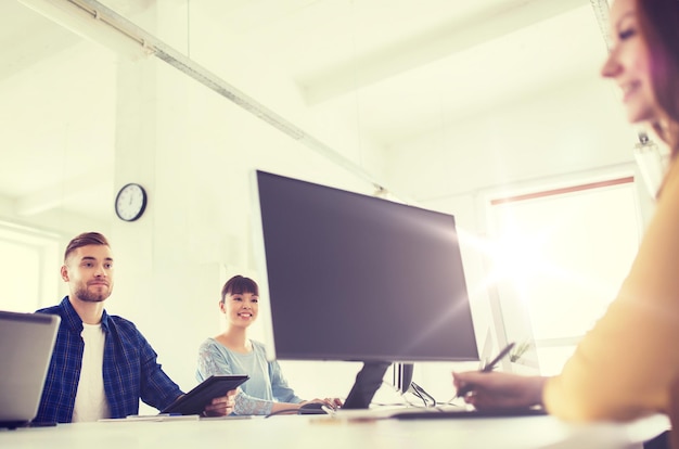 business, startup, technology and people concept - happy creative team with computers at office