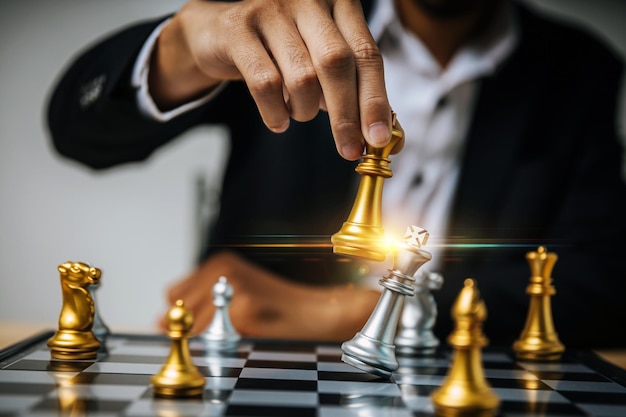 Business strategy. businessman hand moving golden chess figure on chess board game competition, chess battle, business management, leadership  success, team leader, teamwork, business planning concept