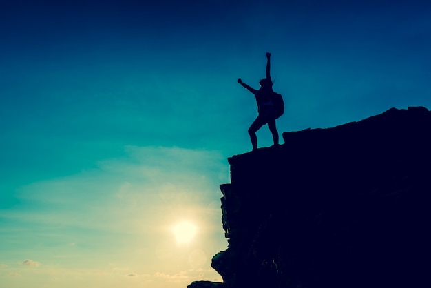 Business success and goal concept. Silhouette climber on the cliff.