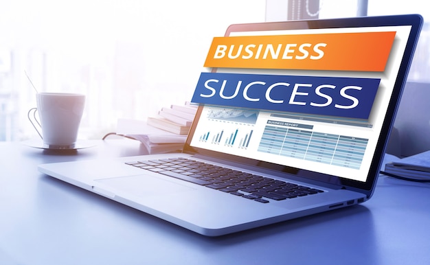 Business success text on laptop screen with graph chart background