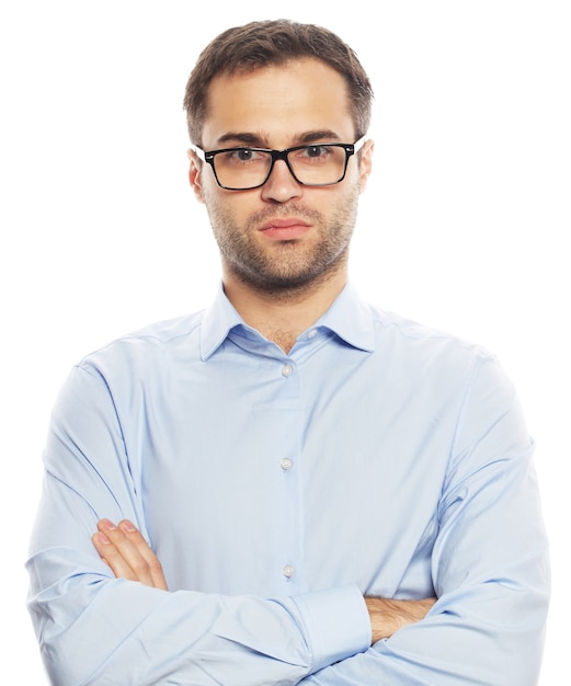 Business, successful and people concept - Handsome young business man in blue shirt looking at camera standing against white background
