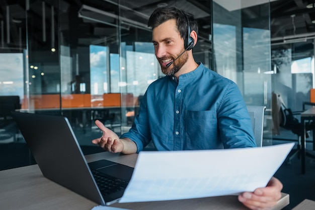 Business talk. Male manager in headphones having a video call