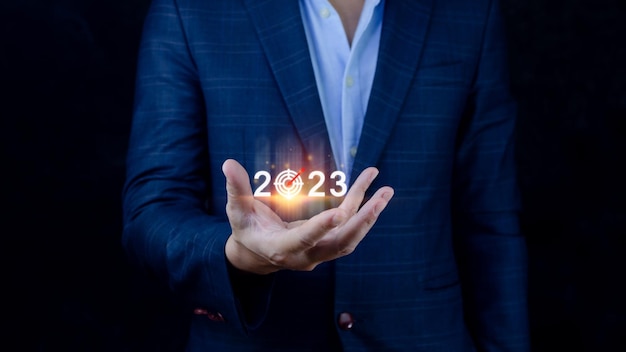 Business target and goal 2023 icon hand pointing holding 2023 virtual screen Start new year 2023 with a goal plan action plan strategy new year business vision