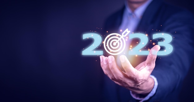 Obiettivo aziendale e obiettivo sulla mano di concetto del nuovo anno 2023 che tiene i nuovi anni dello schermo virtuale 2023