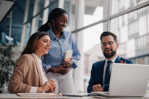 business team analyzing data on laptop in modern office