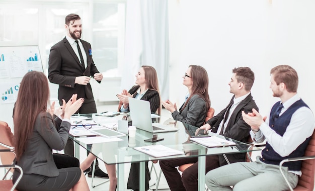 Business team applaudisseren voor de Manager Finance op de presentatie van het nieuwe project op de werkplek