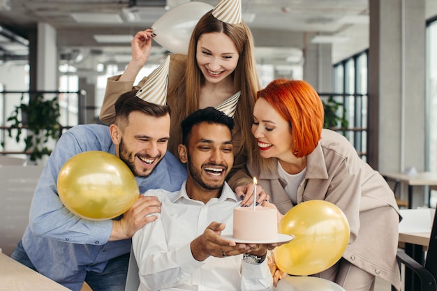 Business team celebrating a birthday of collegue in the modern officexA