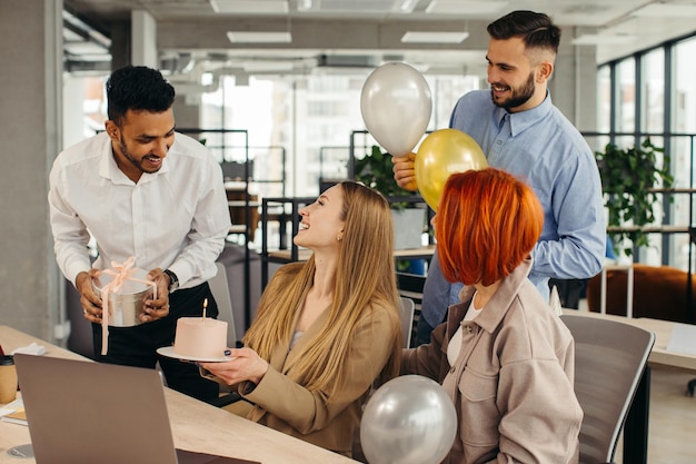 Бизнес-команда празднует день рождения коллеги с тортом в офисе Празднование дня рождения сотрудника на рабочем месте