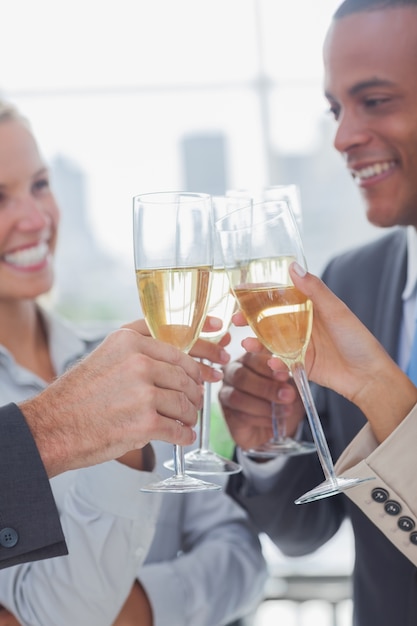 Foto squadra di affari che celebra con champagne e vetri clinking