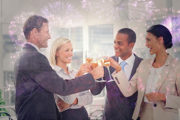 Business team celebrating with champagne and toasting against colourful fireworks exploding on black background