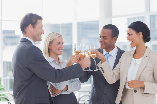 Squadra di affari che celebra con champagne e tostatura