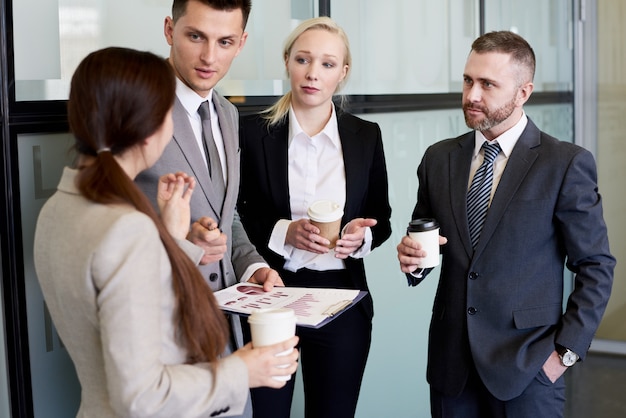 Squadra di affari che chiacchiera alla pausa caffè