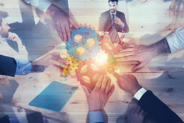 Business team connect pieces of gears Teamwork partnership and integration concept double exposure