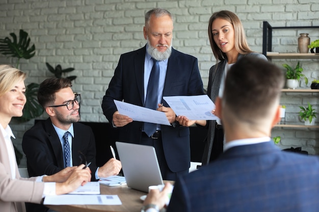 Business team dat op laptop werkt om de resultaten van hun werk te controleren.