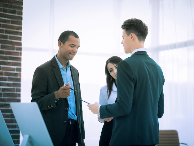 Business team discussing business issues standing in the office