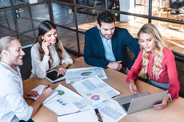 Business team discussing new business project at workplace with papers and laptop in office