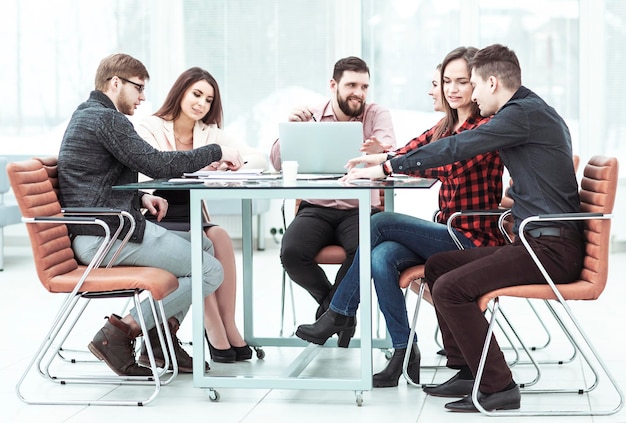 Business team discussing work documents sitting behind a Desk