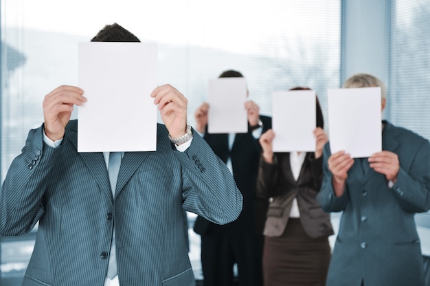 Photo business team of four holding blank paper