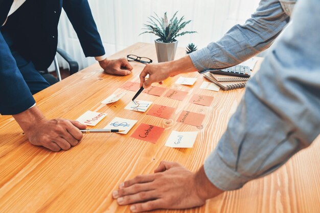 Foto il team aziendale si riunisce sul tavolo per il brainstorming e la scrittura di un'idea creativa fervente