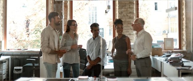 Photo business team group of modern people discussing something at business meeting while standing in the