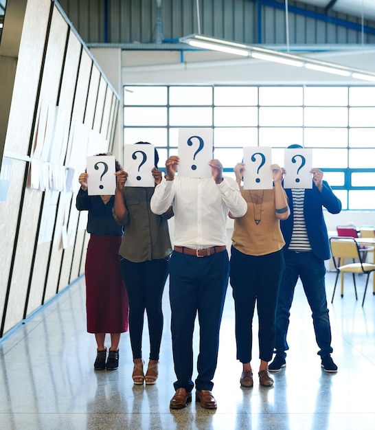 Foto team aziendale e gruppo con poster con punto interrogativo e idee con negoziazione del marchio e soluzione sul posto di lavoro colleghi e uomini del personale con donne che chiedono e confusione con la risoluzione dei problemi