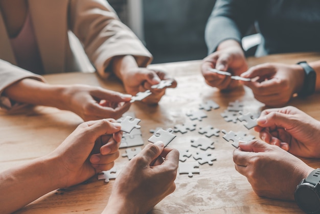 Il team aziendale gestisce un pezzo di puzzle bianco che sta per cadere per ottenere un foglio di lavoro completo - un tentativo di successo.