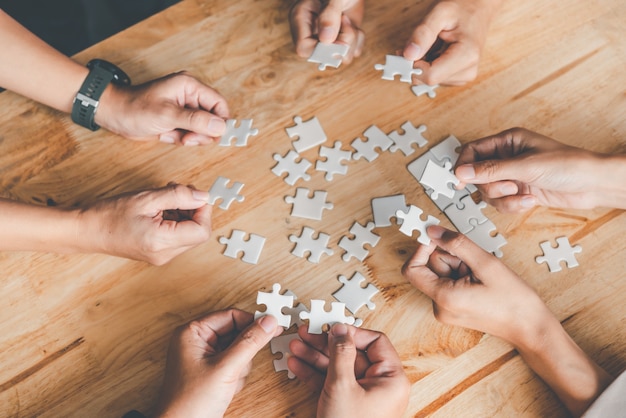 Il team aziendale gestisce un pezzo di puzzle bianco che sta per cadere per ottenere un foglio di lavoro completo - un tentativo di successo.