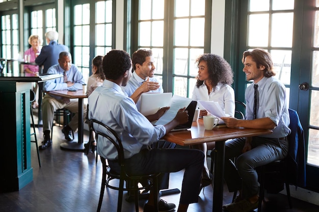 Business Team Having Informal Meeting Around Table In Coffee Shop