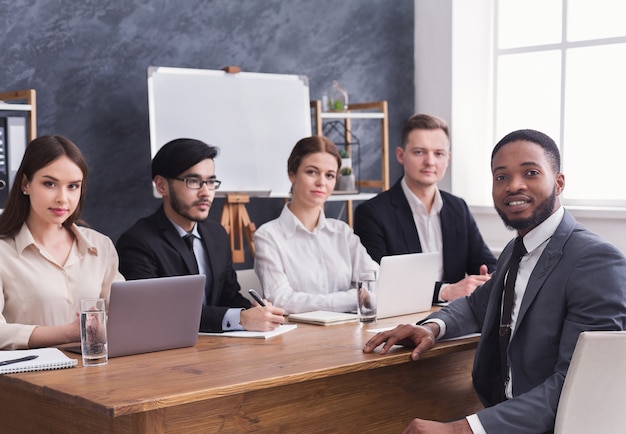 Business team in gesprek met Afro-Amerikaanse sollicitant tijdens werkinterview op kantoor