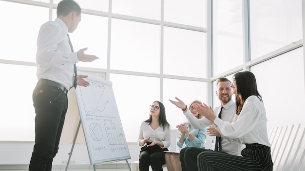 Business team juicht de spreker op een briefing in het nieuwe kantoor. het concept van goed werk