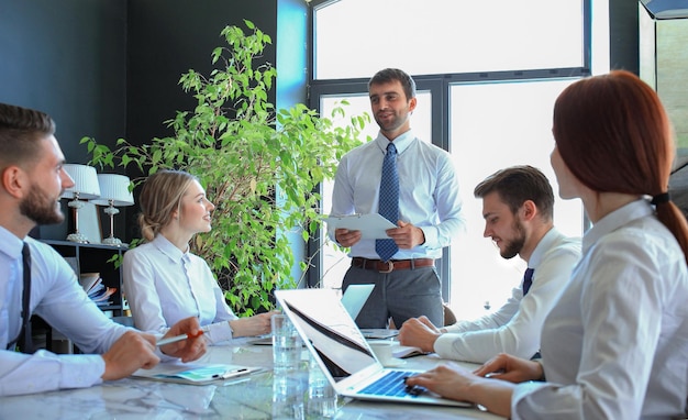 Business team juicht de spreker toe bij de presentatie van het nieuwe project