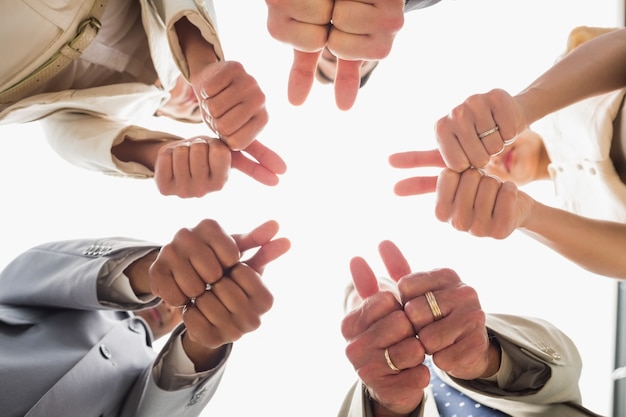 Foto gruppo di affari che esamina giù la macchina fotografica che mostra i pollici su