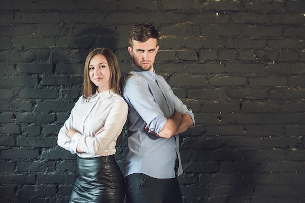 Business team male and female formed of young businessmen standing over a dark surface.