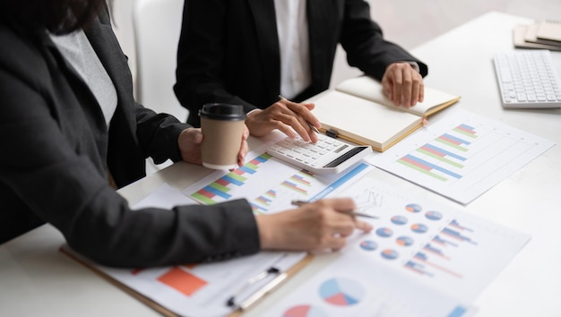 Business team meeting present investor colleagues discussing new plan financial graph data on office table with laptop and calculator Finance accounting investment