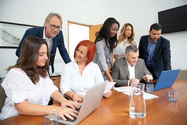 Business team of men and women in an office analyzing the evolution of the company