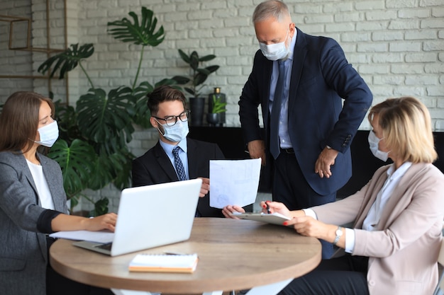 Business team in protective masks works in the office.