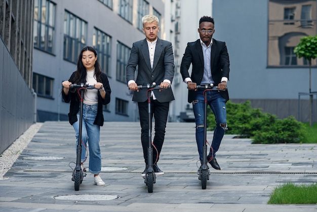 Business team riding electrical scooters