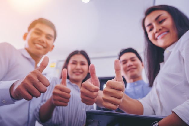 Business team showing thumbs up as like sign. close up hand.