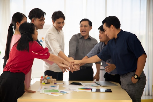 Photo business team showing unity with their hands together. group of people joining hands and representing concept of friendship, teamwork and partnership