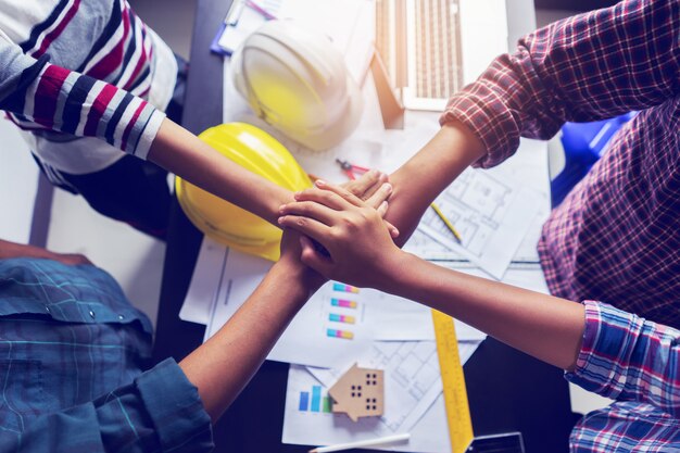 Photo business team standing hands together in office