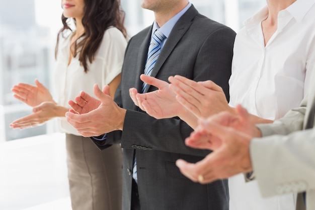 Business team standing in a row applauding