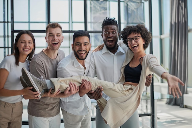 Foto squadra di affari che lancia il suo collega in ufficio