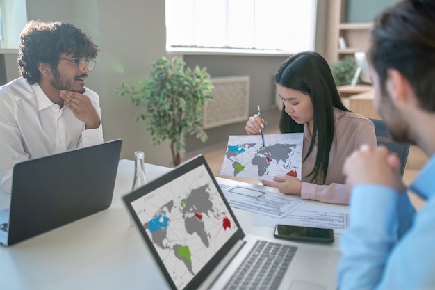 Business team. Two men and woman working in the office and looking involved