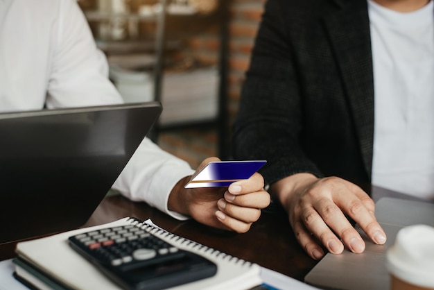 Photo business team use credit cards to conduct financial transactions through phones tablet and laptop in the morning