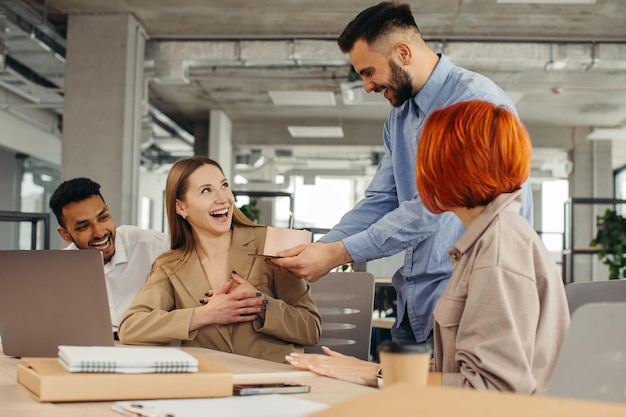 Foto business team viert de verjaardag van een collega met een taart op kantoor de verjaardag van een werknemer vieren op de werkplek