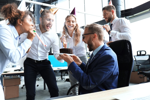 Business team viert een verjaardag van een collega in het moderne kantoor.