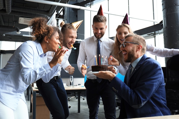 Business team viert een verjaardag van een collega in het moderne kantoor.